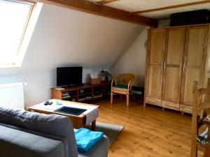 Ferienwohnung am Papensee في Hohen Sprenz: غرفة معيشة مع أريكة وتلفزيون
