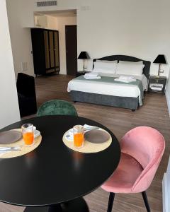 Alèa Rooms في ليتشي: غرفة نوم بسرير وطاولة وكراسي