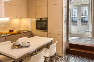 a kitchen with a table and chairs and a window at Cardosas Charming Apartment with Balconies in Porto