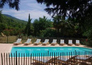 um grupo de cadeiras sentadas ao lado de uma piscina em La Cerisaie - Chambres d'hôtes & gites em Riols