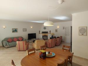 una sala de estar con una mesa y un sofá en The Pinewood Villa, en Vilamoura