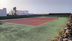 una pista de tenis sobre un campo de césped en THE WHITE HOUSE with Pool - Playa Blanca, en Playa Blanca