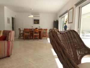 a dining room and living room with a table and chairs at The Pinewood Villa in Vilamoura