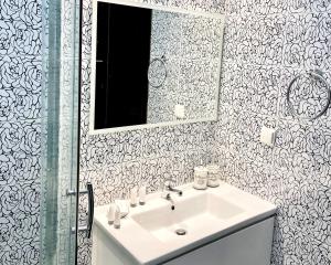 a bathroom with a sink and a mirror at White House Kokas Luxury Apartments in Kremasti +3 photos