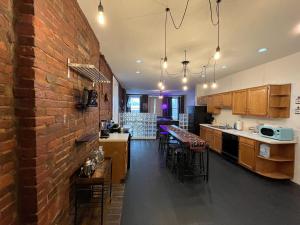 a kitchen with a brick wall and a kitchen with bar stools at Downtown Loft Sleeps 6 - Pool Table Shuffleboard in Louisville