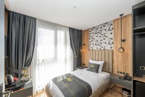 um quarto com uma cama e uma grande janela em Heaven Inn Airport Hotel em Arnavutköy