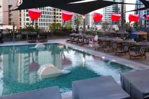 a swimming pool with chairs and tables and red lanterns at Lux Studio in Downtown, 5 mins to Burj Khalifa & Dubai Mall - MAG318 in Dubai