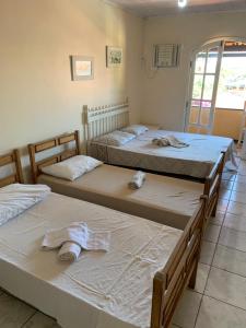 eine Gruppe von 3 Betten in einem Zimmer in der Unterkunft ALOHA LAGOON CABO FRIO in Cabo Frio