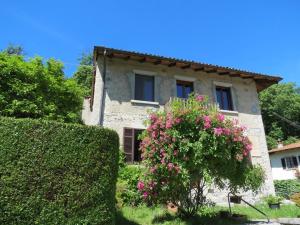 a house with pink flowers in front of it at Appartamento AQUILONE in Mergozzo