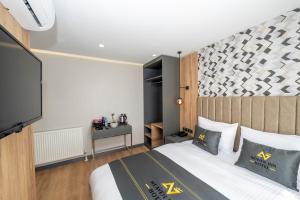 a bedroom with a bed and a flat screen tv at Heaven Inn Airport Hotel in Arnavutköy