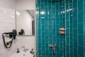 a bathroom with a blue tiled shower and a sink at Heaven Inn Airport Hotel in Arnavutköy