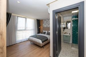 a bedroom with a bed and a bathroom with a shower at Heaven Inn Airport Hotel in Arnavutköy