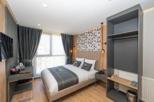 a bedroom with a bed and a large window at Heaven Inn Airport Hotel in Arnavutköy
