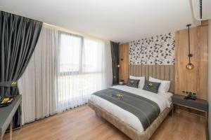 a bedroom with a bed and a large window at Heaven Inn Airport Hotel in Arnavutköy