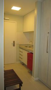 a kitchen with a sink and a red cabinet at Flat Fusion Setor Hoteleiro Norte com serviço diário de limpeza in Brasilia