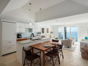 百慕大的住宿－Azura Bermuda，厨房以及带桌椅的起居室。