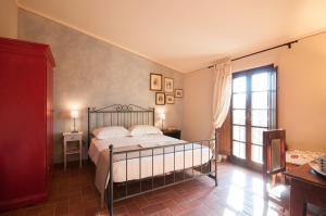 a bedroom with a bed and a large window at Agriturismo Borgo tra gli Olivi in Castiglion Fiorentino +61 photos