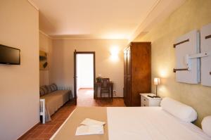 a bedroom with a bed and a table in a room at Agriturismo Borgo tra gli Olivi in Castiglion Fiorentino
