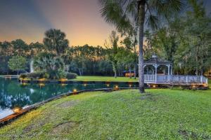 a gazebo in a park next to a lake at Cottage in the woods at Emerald Lakes Estate in Saint Augustine