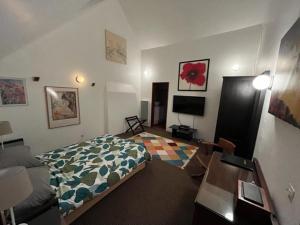 um quarto com uma cama e uma sala de estar em Chez Thomas 7 Route du Monde Ancien em Saint-Georges-dʼAunay