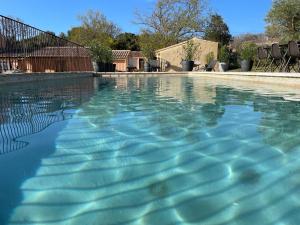 een zwembad met blauw water in een tuin bij Les micocouliers in Lagnes