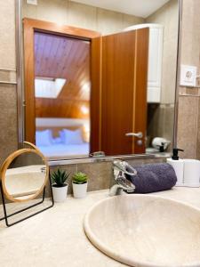 um balcão de casa de banho com um lavatório e um espelho em Elegante Ático Encamp - FREE Parking Wifi SmartTv - Con altillo y 2 baños completos! em Encamp