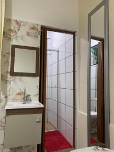 a bathroom with a sink and a mirror at Cantinho de Maria in Aparecida