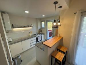 a kitchen with white cabinets and a wooden counter top at PASO SQUARE in La Plata