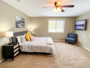 ein Schlafzimmer mit einem Bett, einem Deckenventilator und einem blauen Stuhl in der Unterkunft Yellowstone Getaway in Beautiful Box Canyon in Island Park