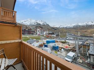 a balcony with a view of a city and mountains at Charmant appartement cosy au centre de Val Thorens avec WiFi - FR-1-640-20 in Val Thorens