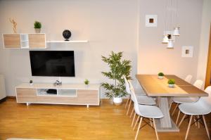 uma sala de estar com uma mesa de jantar e uma televisão em Feeling Home Plaza Mayor em León