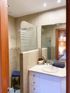 uma casa de banho com um lavatório e um espelho em Elegante Ático Encamp - FREE Parking Wifi SmartTv - Con altillo y 2 baños completos! em Encamp