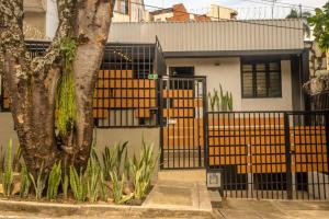 una casa con una recinzione e un albero di FLAWLESS LODGE EN IMBANACO, Cali-Colombia a Cali