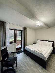 - une chambre avec un lit, une chaise et une fenêtre dans l'établissement Forest Resort, à Băile Tuşnad