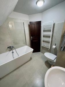łazienka z wanną, toaletą i umywalką w obiekcie Forest Resort w mieście Băile Tuşnad