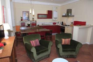 une cuisine avec deux chaises et une table ainsi qu'une salle à manger dans l'établissement Dimora Puccini, à Lucques