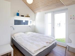 een groot bed in een kamer met een groot raam bij One-Bedroom Holiday home in Ærøskøbing 4 in Brovst