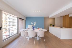 a kitchen and dining room with a white table and chairs at Maison Lily by Exclusive-Stays in Knokke-Heist