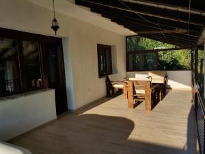 a patio with a table and chairs and windows at Villa River Pehchevo in Pehčevo