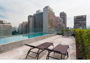 a balcony with chairs and a swimming pool on a building at Studio Harmonia, Moderno, Aconchegante e com Garagem in Sao Paulo