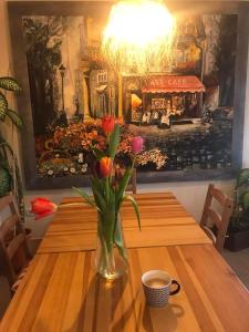 a vase of flowers sitting on a wooden table at Illaberek Turistaház in Sukoró