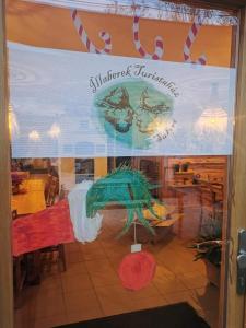 - une fenêtre d'un restaurant munie d'un panneau dans l'établissement Illaberek Turistaház, à Sukoró