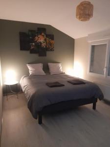ein Schlafzimmer mit einem großen Bett mit zwei Lampen in der Unterkunft Maison de 100M2 avec terrasse in Wardrecques