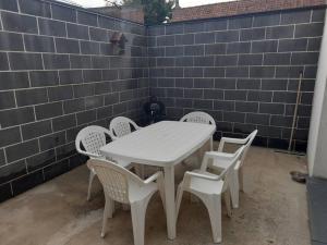 einen weißen Tisch und Stühle auf einer Terrasse in der Unterkunft Maison de 100M2 avec terrasse in Wardrecques