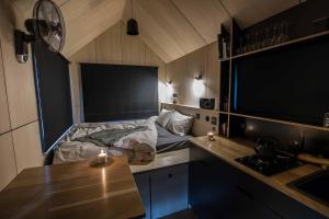 um pequeno quarto com uma cama e uma mesa em L'Envolée Ecolodge, tiny house au coeur des vignes em Loches-sur-Ource