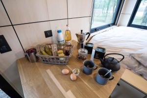 einen Tisch mit einem Korb mit Speisen und Eiern auf dem Bett in der Unterkunft L'Envolée Ecolodge, tiny house au coeur des vignes in Loches-sur-Ource