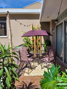 eine Terrasse mit einem Tisch, Stühlen und einem Sonnenschirm in der Unterkunft Apartamentos 649 in Guatemala