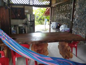 a wooden table with a hammock around it in a kitchen at La chonta in Capurganá