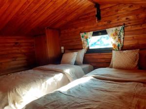 1 dormitorio con 2 camas en una cabaña de madera en Kozalak Bungalov Kozak Yaylası, en Çamoba