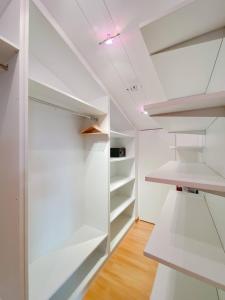 un armario vacío con estanterías blancas y techo en Elegante Ático Encamp - FREE Parking Wifi SmartTv - Con altillo y 2 baños completos!, en Encamp